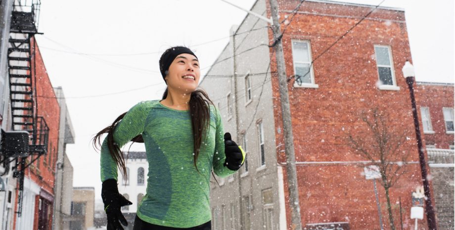 Woman running outside with winter clothes on.