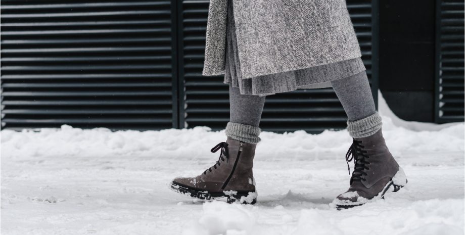 Someone walking through snow with boots on their feet.